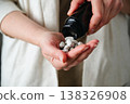 Woman pouring a pile of pills, capsules from a bottle in hand. Prescription medication, treatment sickness concept 138326908