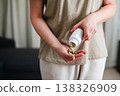 Woman pouring a pile of pills, capsules from a bottle in hand. Prescription medication, treatment sickness concept 138326909