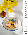 Easter spring background. Easter cookies with colourful icing: bunnies, carrots and eggs in a plate with bouquet of fresh. Bright and airy photo 138326915