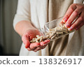 Woman pouring a pile of pills, capsules from a bottle in hand. Prescription medication, treatment sickness concept 138326917