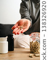 Food supplements and vitamins. Woman holding a pill capsules with pill bottles at home, healthy care concept. 138326920