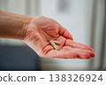 Woman hand closeup, holding capsules pills. Prescription medication, treatment sickness, seasonal cold flu concept 138326924