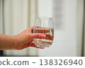 Woman holding a glass of drinking water, hydration, healthy lifestyle. Neutral background 138326940