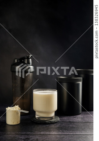 Protein drink in a glass with protein shaker and tube on dark background. Body building, muscle growth and food supplement concept 138326945