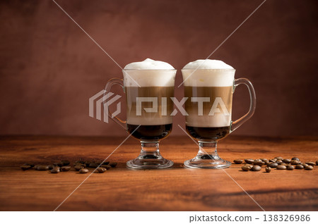 Layered coffee latte drinks. Hot coffee drinks in glass mugs, brown background 138326986