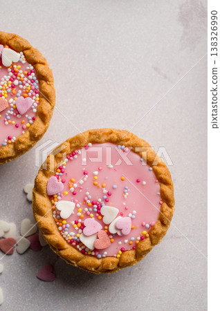 Valentine's day dessert. Pink mini tarts with heart shaped sprinkles. Top view Valentine's day dessert. Pink mini tarts with heart shaped sprinkles. Top view 138326990