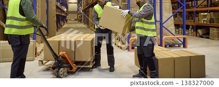 Warehouse workers handling boxes during inventory control with pallet jack 138327000