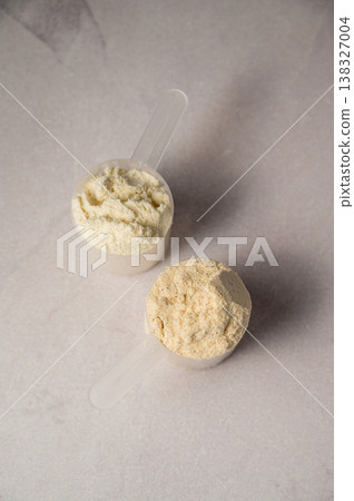 Protein powder in scoops. Body building, muscle growth and food supplement concept Protein powder in scoops. Body building, muscle growth and food supplement concept 138327004