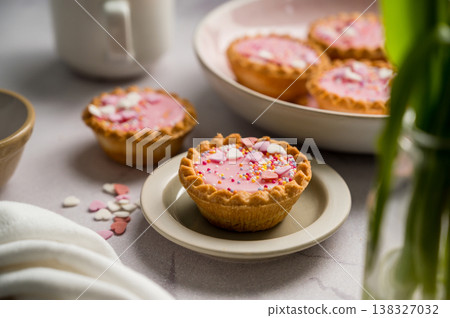 Valentine's day. Pink mini tarts with heart shaped sprinkles and cup of coffee. Valentine's day. Pink mini tarts with heart shaped sprinkles and cup of coffee. 138327032