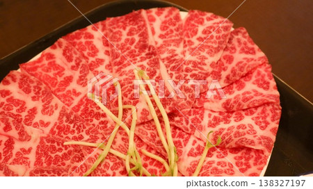 close up of marbled red raw beef meat slice arranged in circular pattern with bean sprout garnish on a plate which is ingredient for hot pot with copy space close up of marbled red raw beef meat slice arranged in circular pattern with bean sprout garnish on a plate which is ingredient for hot pot with copy space 138327197