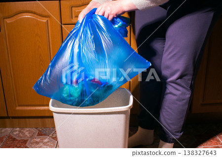 Front view of woman taking out garbage bag from container in home kitchen. High quality Front view of woman taking out garbage bag from container in home kitchen. High quality 138327643