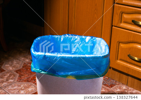 Empty trash bin with blue garbage bag on home kitchen 138327644