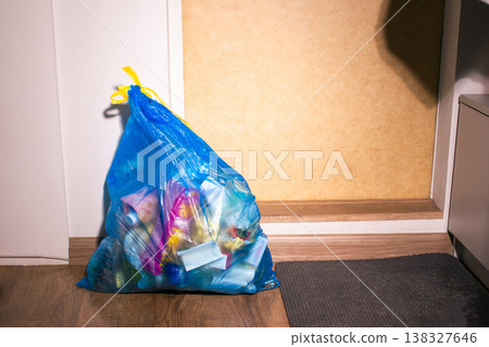 Blue plastic bag for trash waste near home entry door ready to be thrown away. High quality Blue plastic bag for trash waste near home entry door ready to be thrown away. High quality 138327646