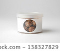 Small plastic container with blank label and lid filled with sesame seed snack balls 138327829