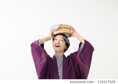 A woman wearing a yukata and holding a bucket A woman wearing a yukata and holding a bucket 138327929