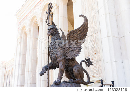 A statue of a lion with wings and a staff. A statue of a lion with wings and a staff. 138328128