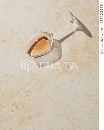 Spilled white wine glass on light stone surface, top view Spilled white wine glass on light stone surface, top view 138328178