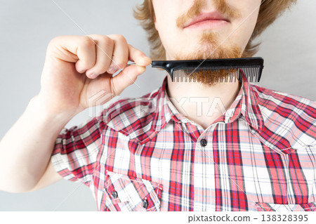 Man combing his beard 138328395