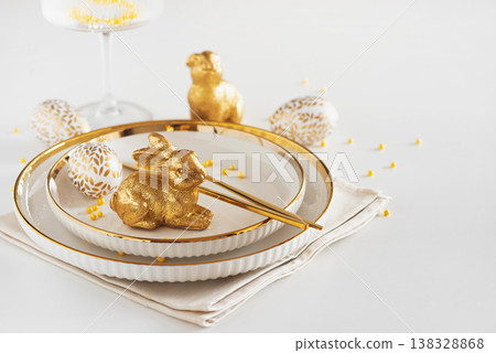 Easter Table Setting with Plates and Golden Decor on White Table Easter Table Setting with Plates and Golden Decor on White Table 138328868