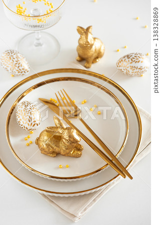 Easter Table Setting with Plates and Golden Decor on White Table 138328869