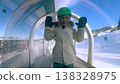 Little Girl In Helmet Riding Covered Magic Carpet Lift At Ski Resort in Chamrousse, French Alps 138328975