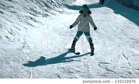 Little Girl Skiing Cautiously Down Gentle Slope At Ski Resort 138328976
