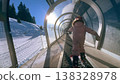 A small child riding a covered magic carpet lift on skis at a ski resort in the French Alps 138328978