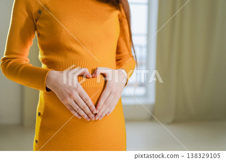 Pregnancy motherhood expectation future. Pregnant woman hands touching big belly. Girl making heart shape with hands enjoying pregnancy. Pregnant woman showing heart sign. Maternity love new life Pregnancy motherhood expectation future. Pregnant woman hands touching big belly. Girl making heart shape with hands enjoying pregnancy. Pregnant woman showing heart sign. Maternity love new life 138329105