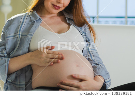 Pregnancy motherhood people expectation future. Pregnant woman hands touching big belly. Girl hugging her tummy enjoying pregnancy at home. Maternity tenderness parenthood new life concept Pregnancy motherhood people expectation future. Pregnant woman hands touching big belly. Girl hugging her tummy enjoying pregnancy at home. Maternity tenderness parenthood new life concept 138329191