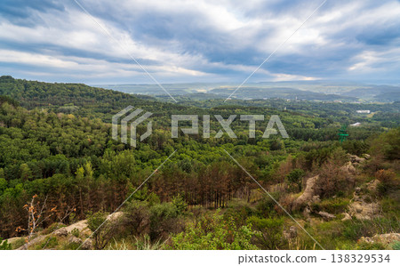 Majestic rocky cliffs and towering pine trees against blue sky. 138329534