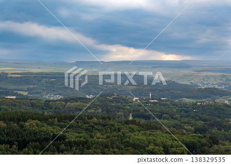Layers of green mountains and hills in the haze during sunset. Panoramic View of Green hills and Meadow. 138329535