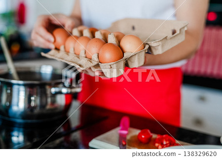 Close up of woman cooking healthy meal in modern kitchen while preparing eggs. 138329620