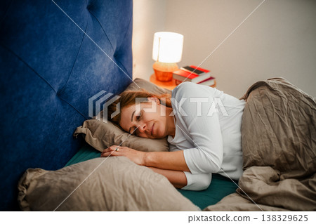 Tired middle aged woman sleeping in bed. 138329625