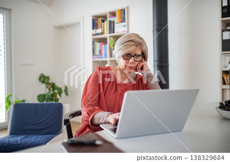 Senior woman working on laptop at home office during retirement. Senior woman working on laptop at home office during retirement. 138329684