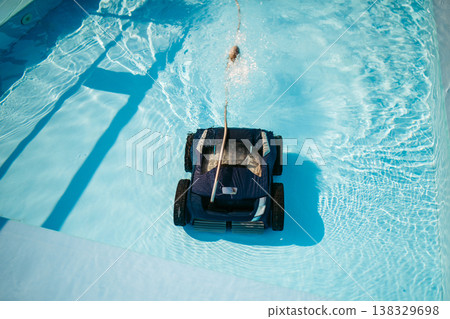 Robotic pool cleaner working underwater to keep swimming pool clean. Robotic pool cleaner working underwater to keep swimming pool clean. 138329698