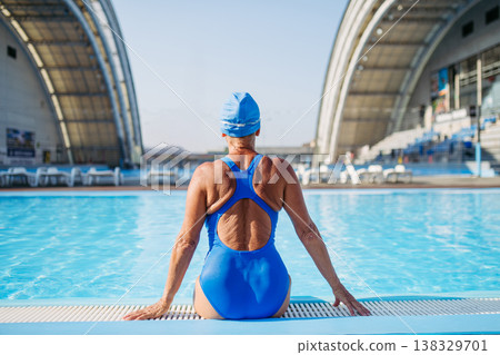 Rear view of older woman getting ready for swim. Rear view of older woman getting ready for swim. 138329701