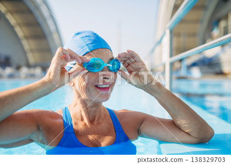 Elderly woman in swimming pool. Older female exercising for vitality and longevity. 138329703