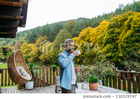 Man is enjoying cup of warm tea, coffee, having relaxing moment at home. Man is enjoying cup of warm tea, coffee, having relaxing moment at home. 138329747