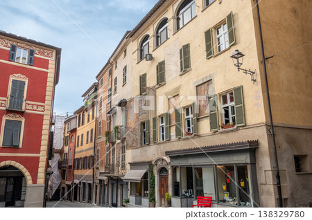 Mondovi (cuneo), italy, july 21, 2024. Colorful building facades lining a narrow street in mondovi, cuneo, italy, showcasing traditional architecture and shutters Mondovi (cuneo), italy, july 21, 2024. Colorful building facades lining a narrow street in mondovi, cuneo, italy, showcasing traditional architecture and shutters 138329780