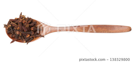 Whole dried clove buds in a dark wooden spoon, isolated on background Whole dried clove buds in a dark wooden spoon, isolated on background 138329800