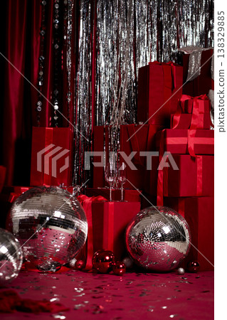 Festive red background with gift boxes, disco balls and sparkling tinsel Festive red background with gift boxes, disco balls and sparkling tinsel 138329885