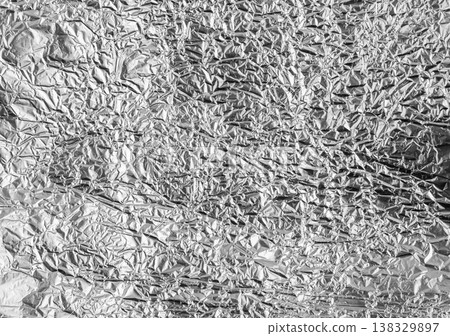 Shiny aluminum foil with wrinkled texture and reflective chrome surface offers a versatile metallic 138329897
