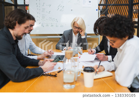 Teamwork brainstorm. Coworkers cooperating working together at office meeting. Colleagues discussing project ideas. Group of people in creative office discussing business. Young professional team 138330105