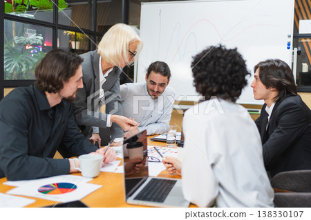 Teamwork brainstorm. Coworkers cooperating working together at office meeting. Colleagues discussing project ideas. Group of people in creative office discussing business. Young professional team Teamwork brainstorm. Coworkers cooperating working together at office meeting. Colleagues discussing project ideas. Group of people in creative office discussing business. Young professional team 138330107