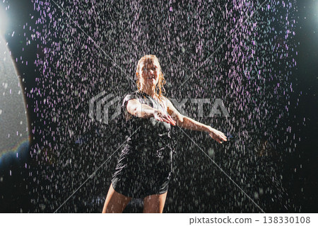 Contemporary woman dancer posing in rain water on black background. Female artist performer dancing with expression. Modern ballerina dancing in darkness. Passion dance in dark. Flexibility balance Contemporary woman dancer posing in rain water on black background. Female artist performer dancing with expression. Modern ballerina dancing in darkness. Passion dance in dark. Flexibility balance 138330108