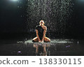 Contemporary woman dancer posing in rain water on black background. Female artist performer dancing with expression. Modern ballerina dancing in darkness. Passion dance in dark. Flexibility balance 138330115