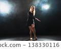 Contemporary woman dancer posing on black background with smoke. Adult female artist performer dancing with expression. Modern ballerina dancing in darkness. Passion dance in dark. Flexibility balance 138330116