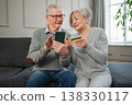 Senior couple man woman shopping online with smartphone paying with credit card. Old people buying on Internet enter credit card details at home indoors. Online shopping delivery service ecommerce 138330117