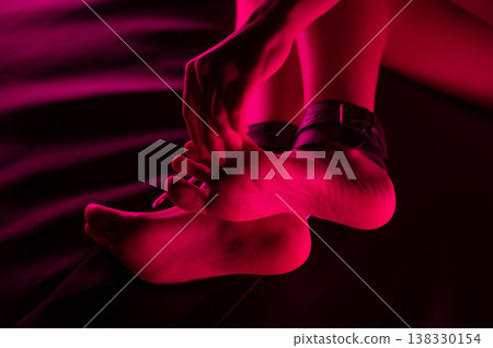 Women's legs in leather shackles. BDSM fetish. Women's legs in leather shackles. BDSM fetish. 138330154