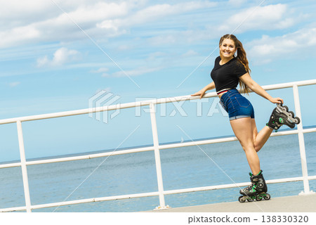 Girl wearing roller skates on seaside Girl wearing roller skates on seaside 138330320